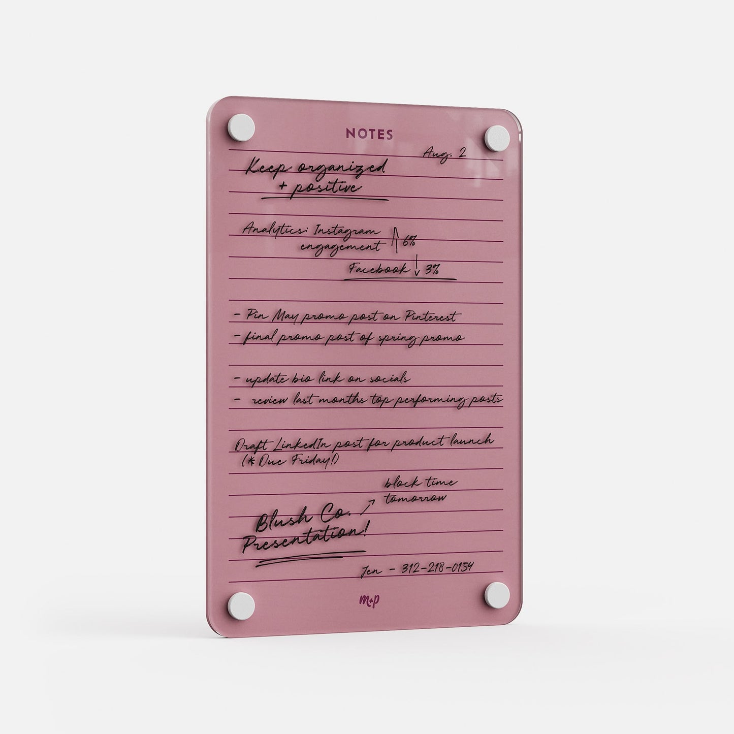 The Lined Notes 69 is a pink glass planning board with white rounded corners and four silver fasteners, displaying neatly organized handwritten notes, reminders, lists, and a phone number in black ink.