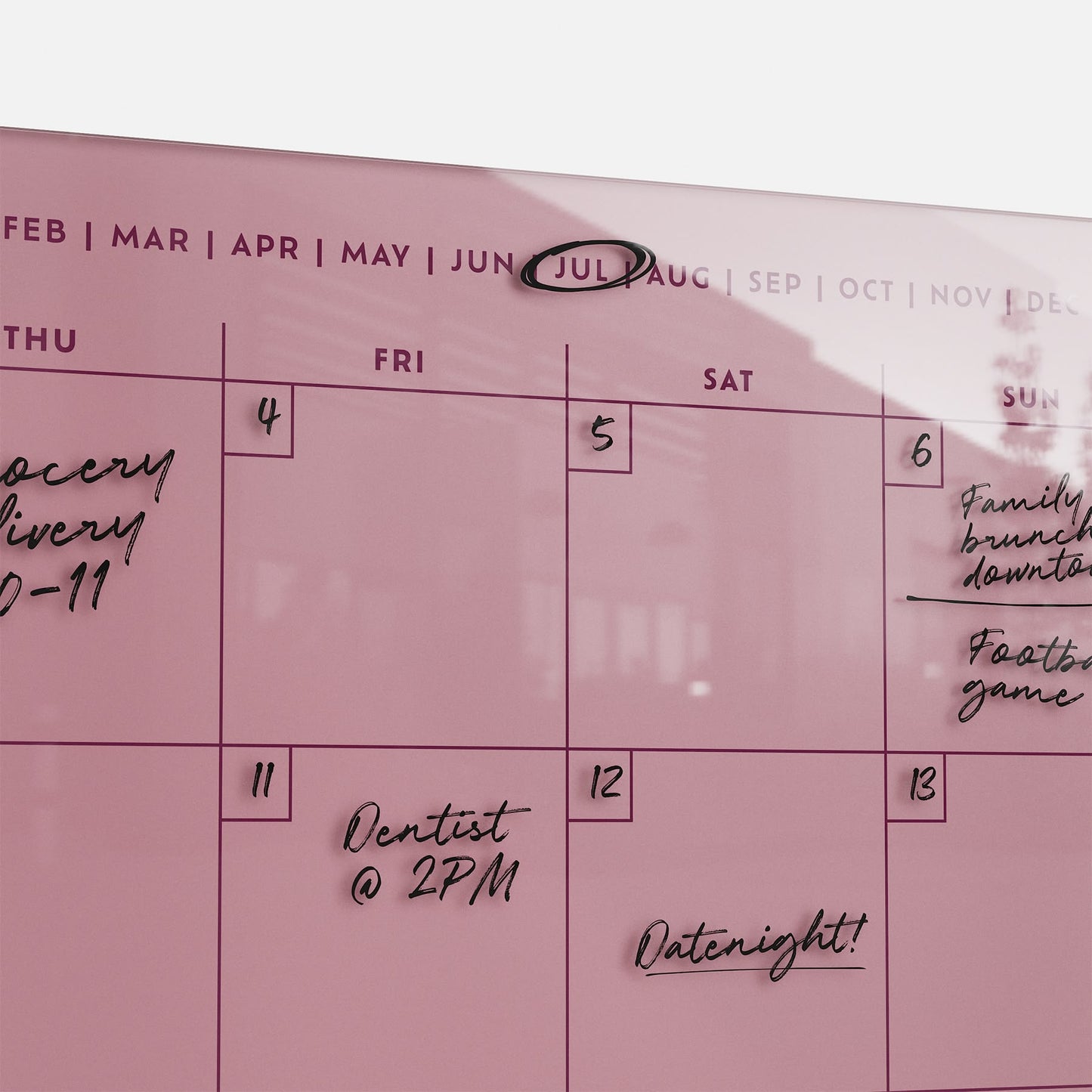 The premium Monkey and Pebbles Monthly Calendar 1411 is a pink acrylic board, erasable and reusable, with July's plans written in.