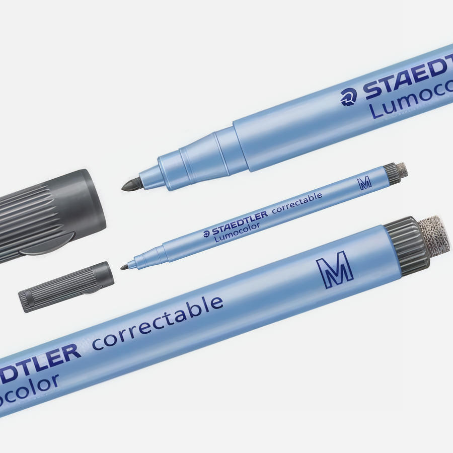 A blue Staedtler Correctable Marker with its cap off reveals a vivid felt tip and eraser. The marker, cap, tip, and eraser are shown separately against a white background.