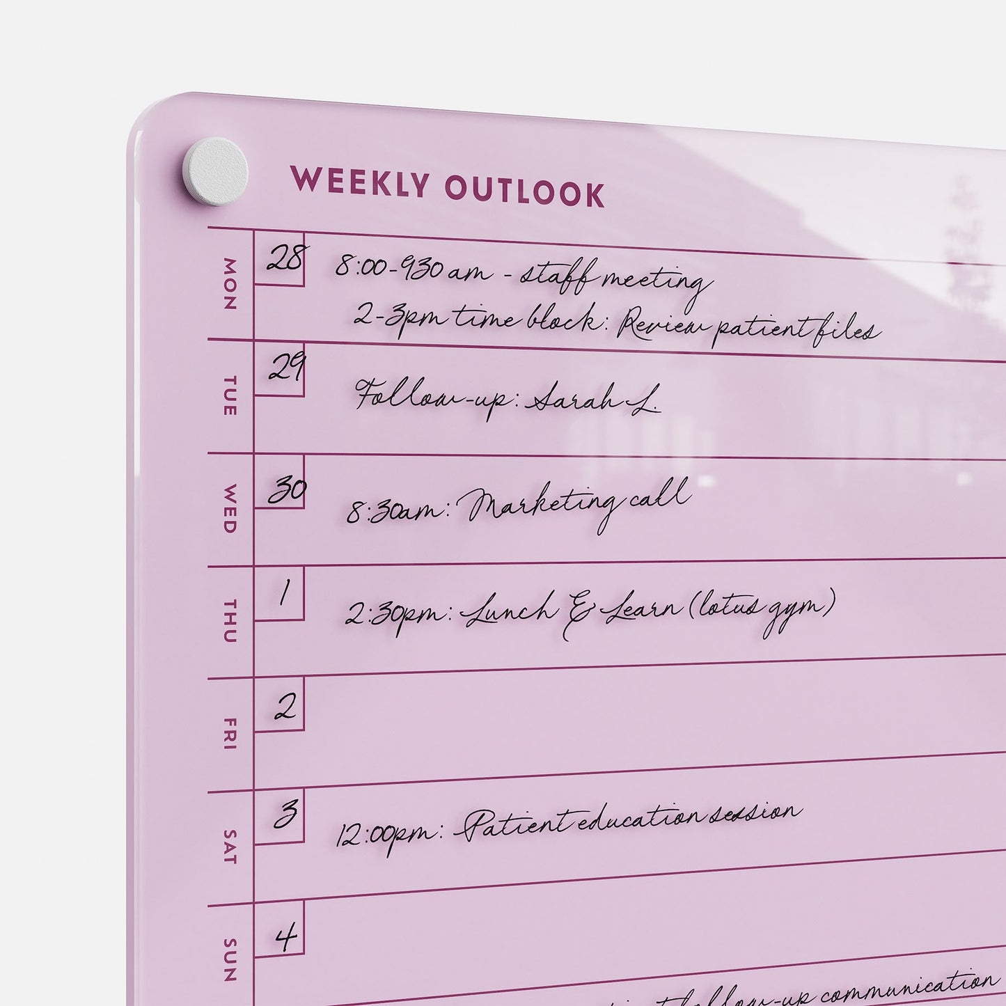 The Weekly Outlook 811 is a pink dry-erase planner and productivity organizer, featuring days of the week listed vertically and dated tasks—like meetings, calls, and reminders—written in black marker for easy scheduling.