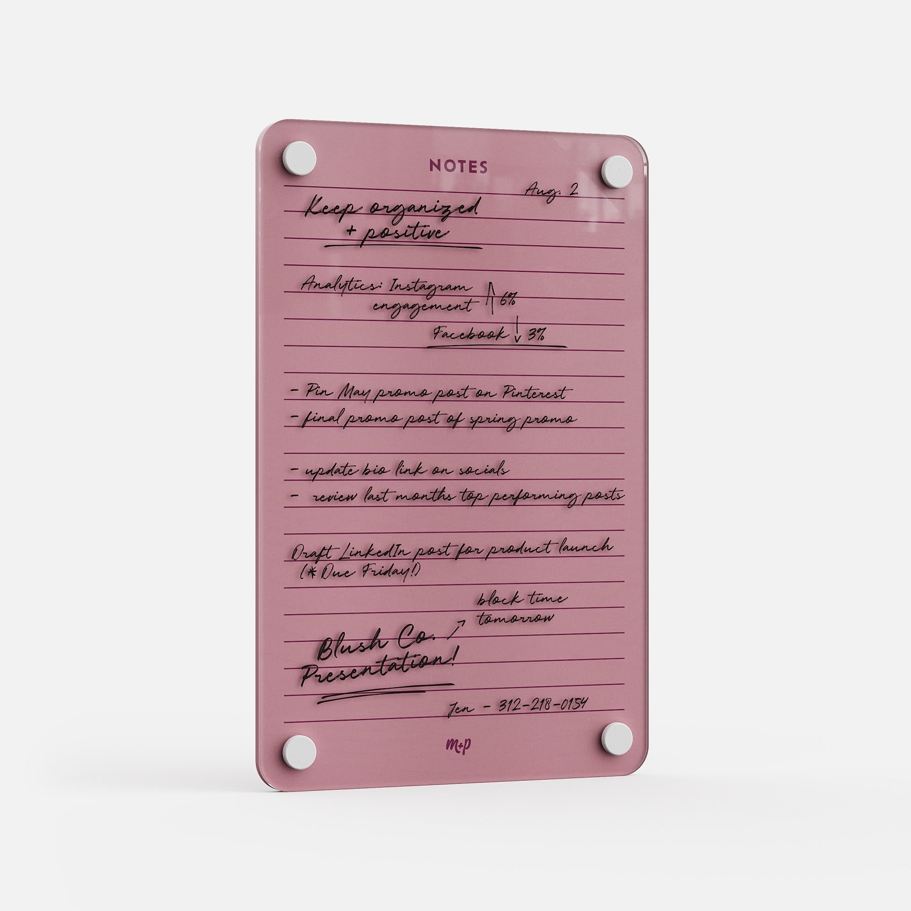 The Lined Notes 69 is a pink glass planning board with white rounded corners and four silver fasteners, displaying neatly organized handwritten notes, reminders, lists, and a phone number in black ink.