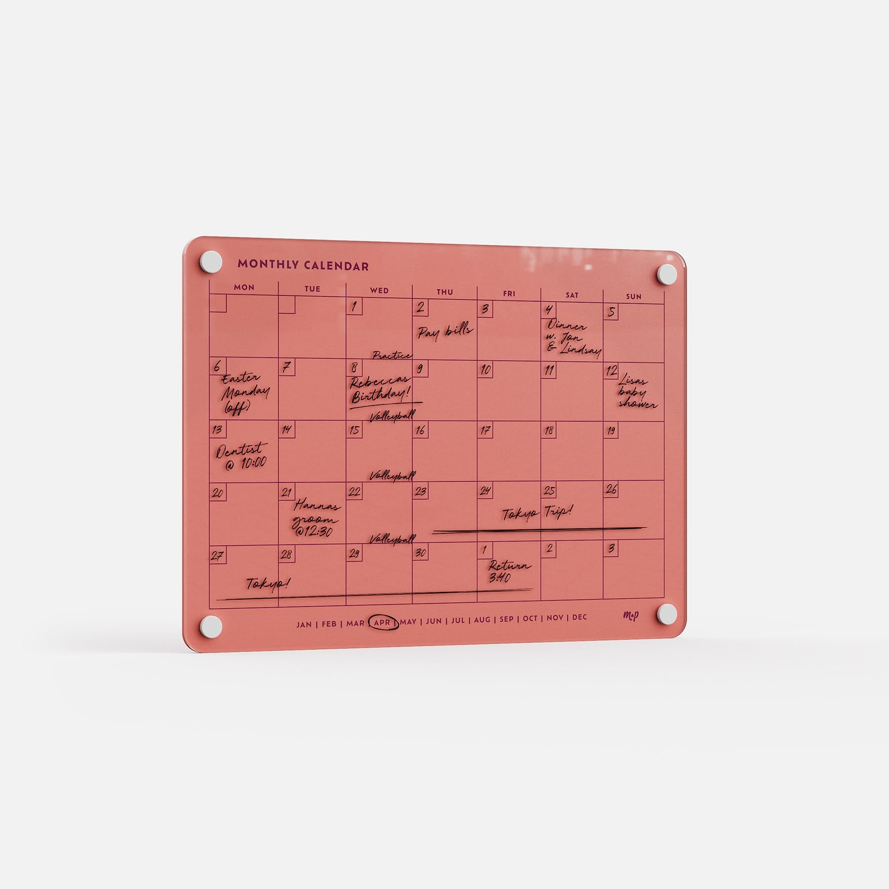 The Monthly Calendar 118 is a coral, compact dry-erase board with handwritten events, four corner holes for hanging, and small month labels along the bottom—ideal as a family organizer.