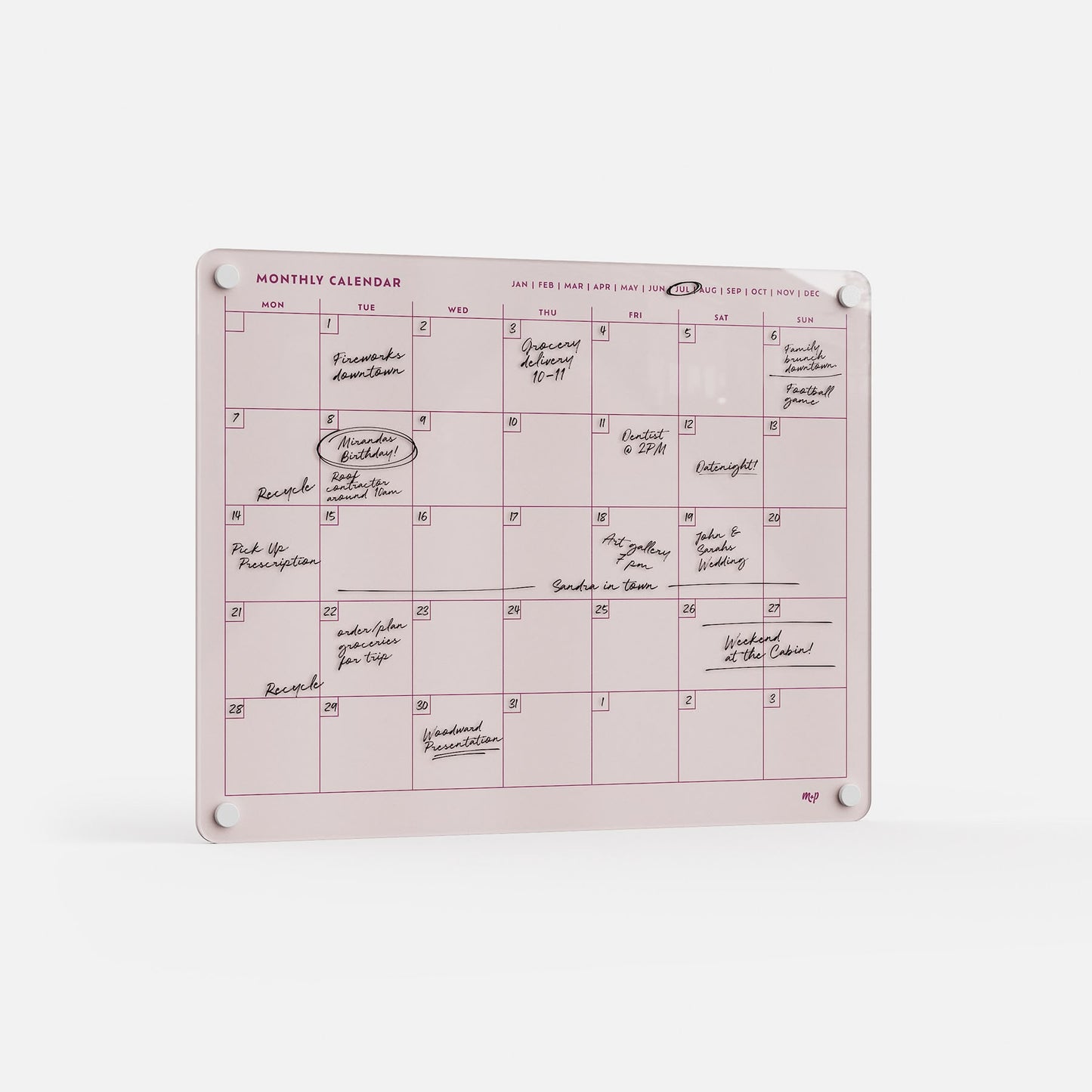The Monthly Calendar 1411 is a pink dry-erase planner with handwritten notes and events. Ideal for family scheduling, it mounts on a white wall with four round magnets at the corners for easy planning and organization.