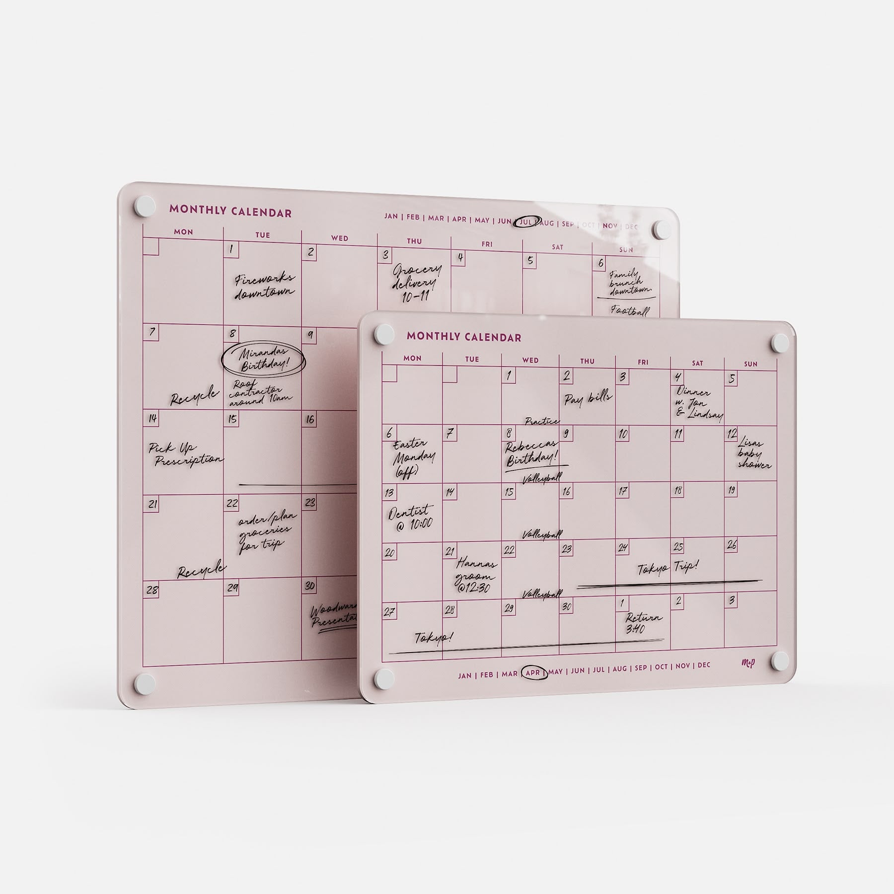 Two pink Monthly Calendar 1411 dry-erase boards serve as a stylish family planner to track plans, with handwritten black text and white corner magnets. They stand upright, overlapping to display events and reminders.