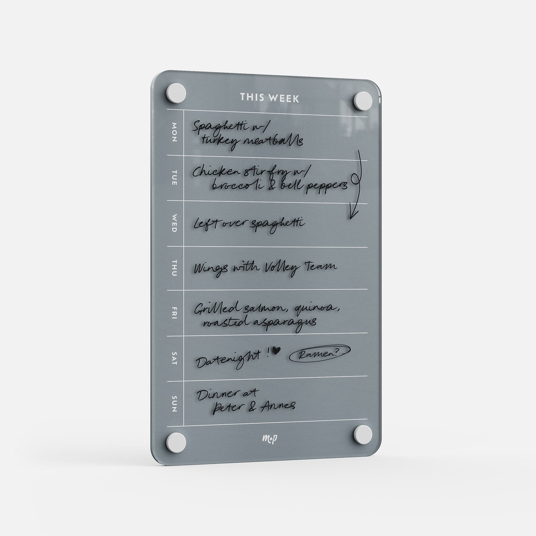 The This Week 69 is a gray glass weekly organizer featuring handwritten meal plans like spaghetti, chicken stir fry, wings, and grilled salmon. With days listed Monday to Sunday, it’s the perfect kitchen meal planner.