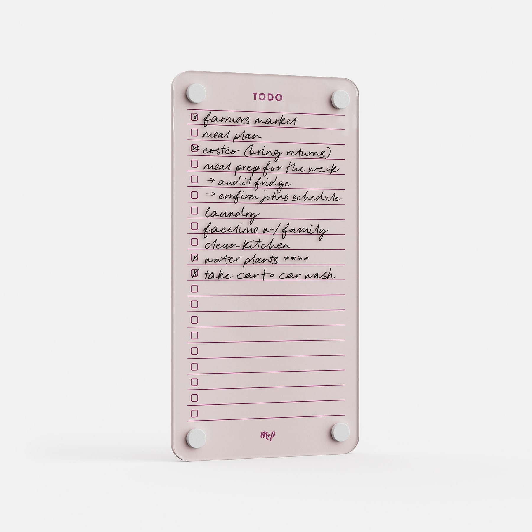 The Todo List 59 is a pink, rectangular magnetic daily dry-erase board with handwritten tasks—like farmers market and clean kitchen—some checked off. Mounted with four round magnets for easy display.