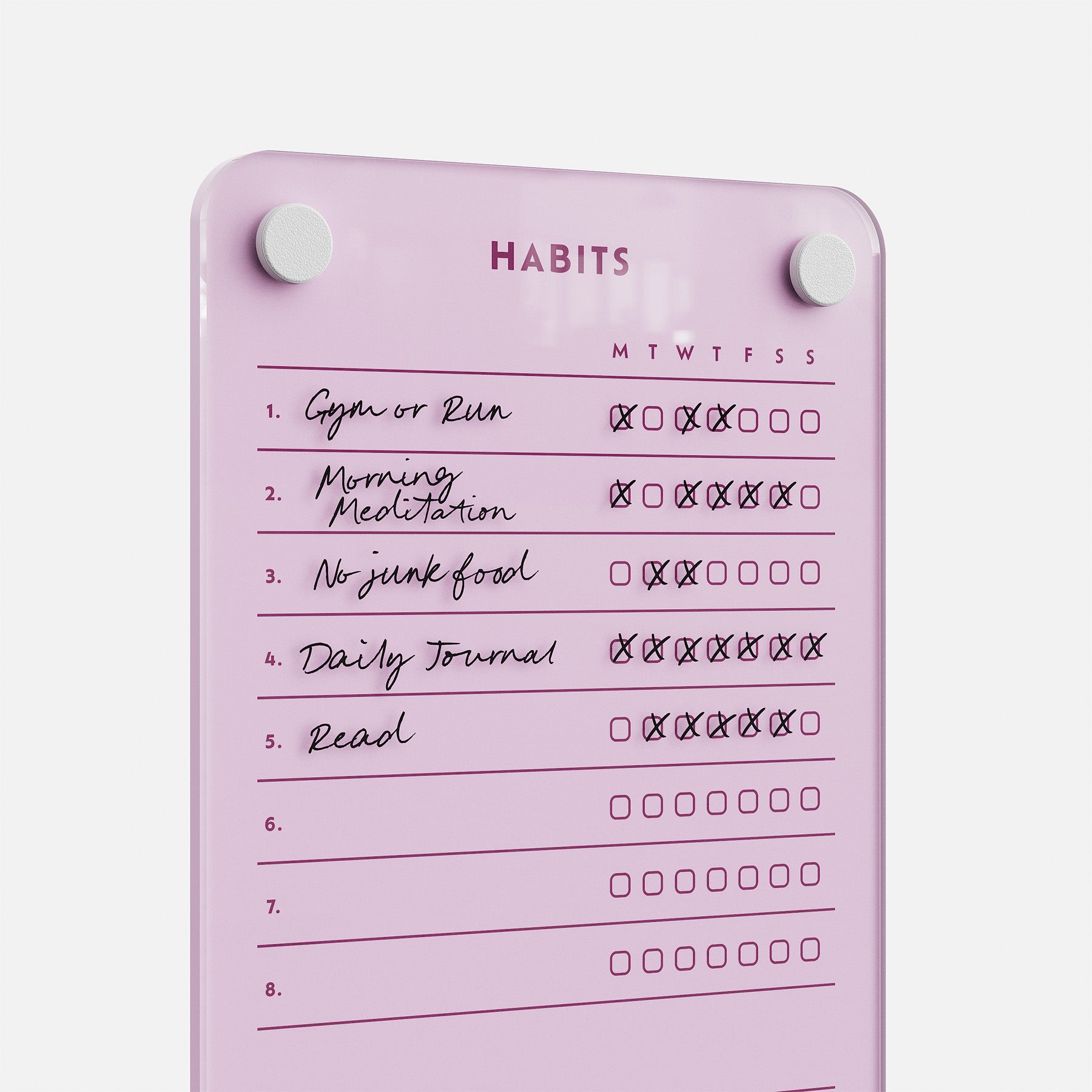 The Weekly Habits 59 board is a pink dry-erase tracker featuring checkboxes for days of the week and five habits: Gym or Run, Morning Meditation, No junk food, Daily Journal, and Read—some boxes are already checked to show progress.