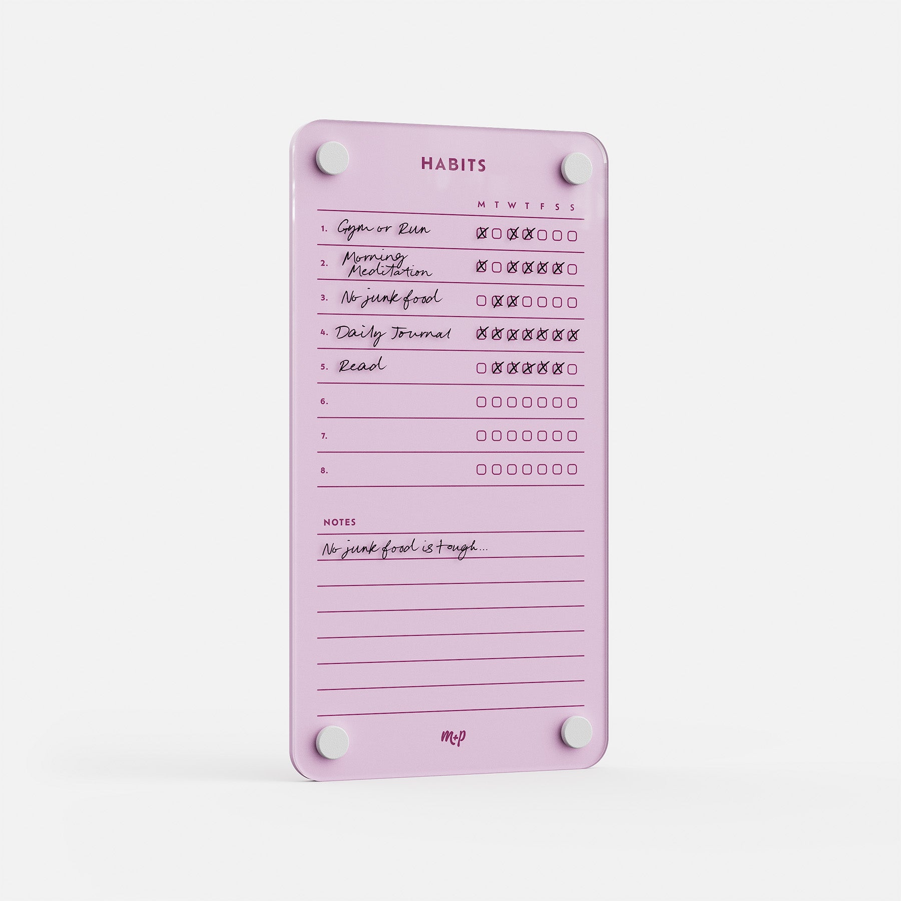 The Weekly Habits 59 pink magnetic tracker shows handwritten habits like Morning Meditation and Read, with daily checkboxes and a note at the bottom that says "No junk food is tough.