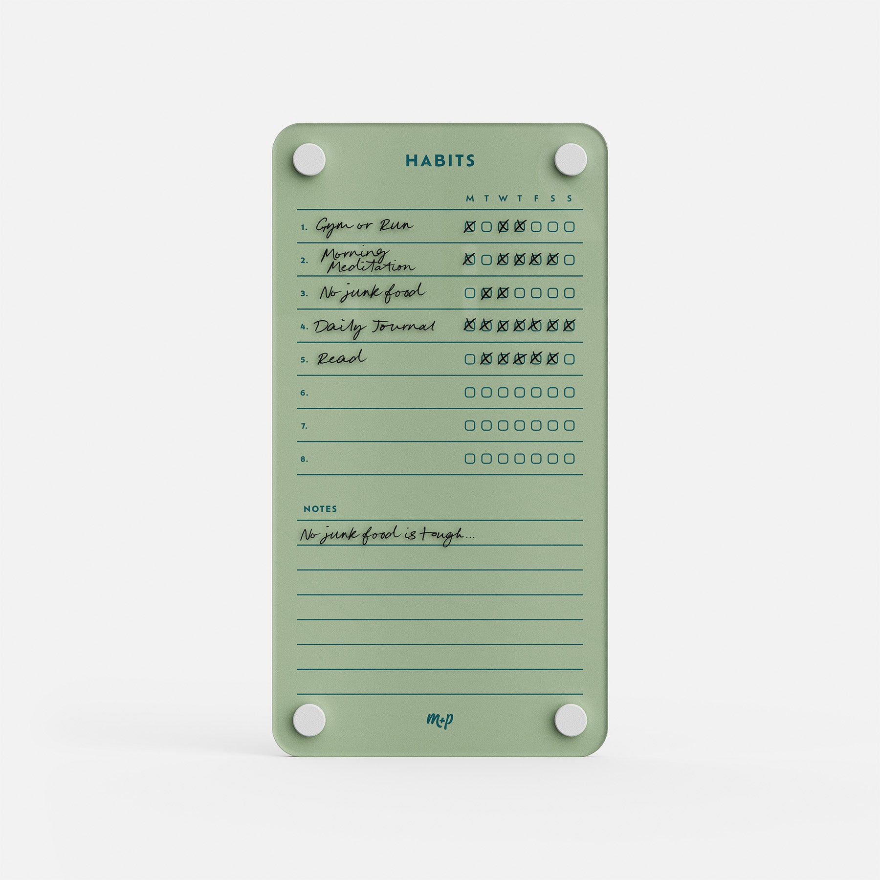 Premium acrylic erasable and reusable green habit tracker with handwritten daily goals, Xs/circles, and a note: “No junk food is tough...”.