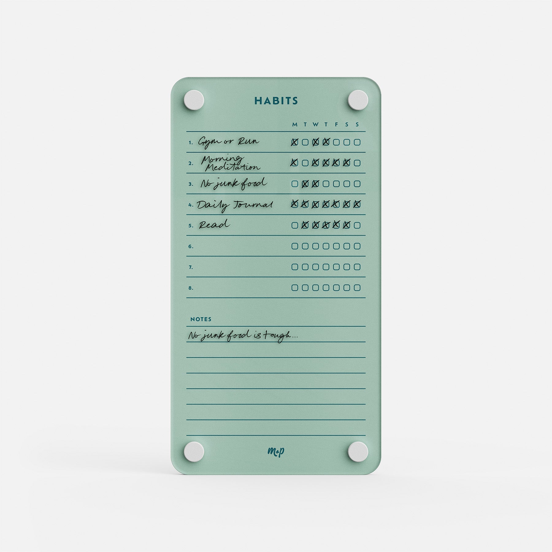 Premium acrylic erasable, reusable habit tracker in teal with six weekly goals, checked boxes, and a “No junk food is tough” note.