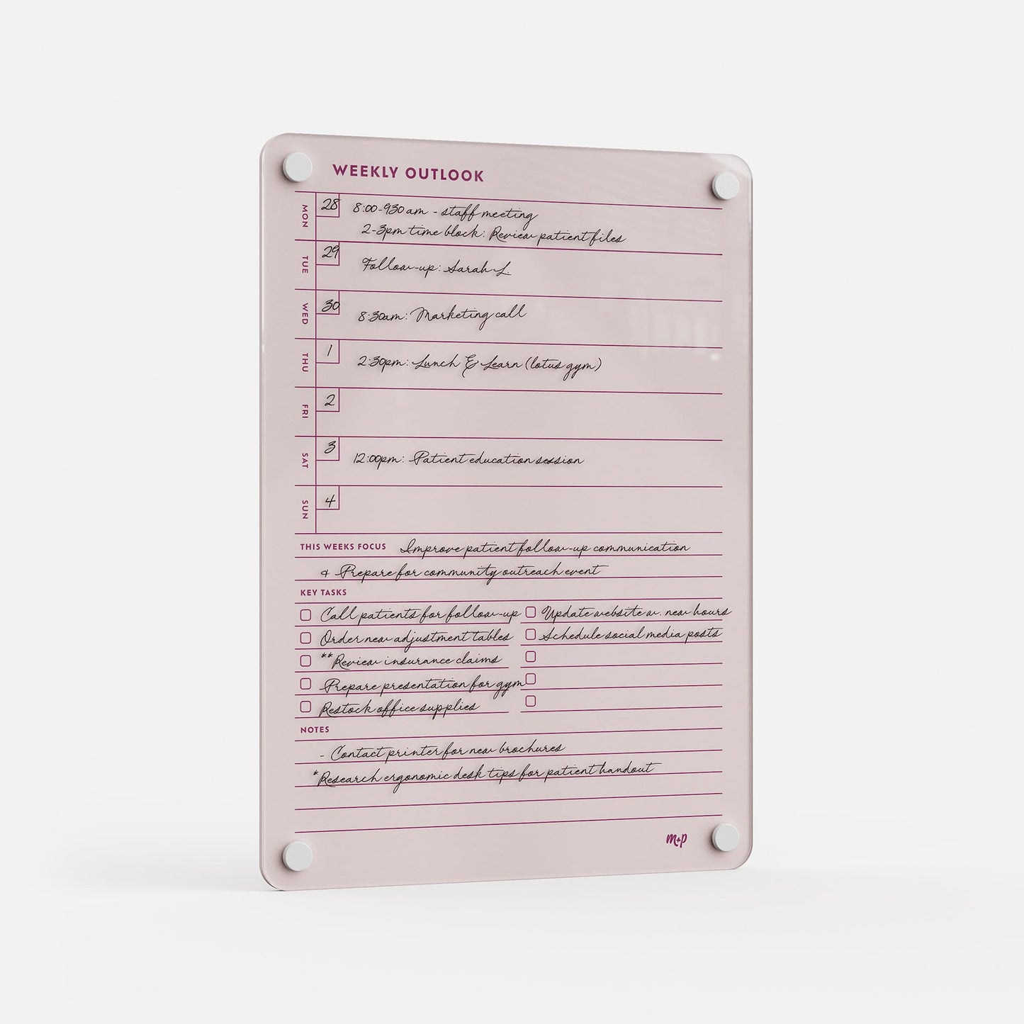 The Weekly Outlook 811 is a pink weekly planner board with handwritten notes, schedules, checkboxes for tasks, space for weekly focus and key ideas. It mounts easily using four white corner magnets.