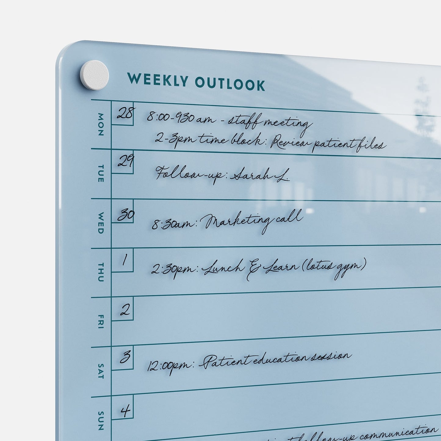 The Weekly Outlook 811, a blue glass planner board, organizes productivity with dated sections and handwritten notes for meetings and events like staff meeting, patient file review, marketing call, and lunch & learn sessions.